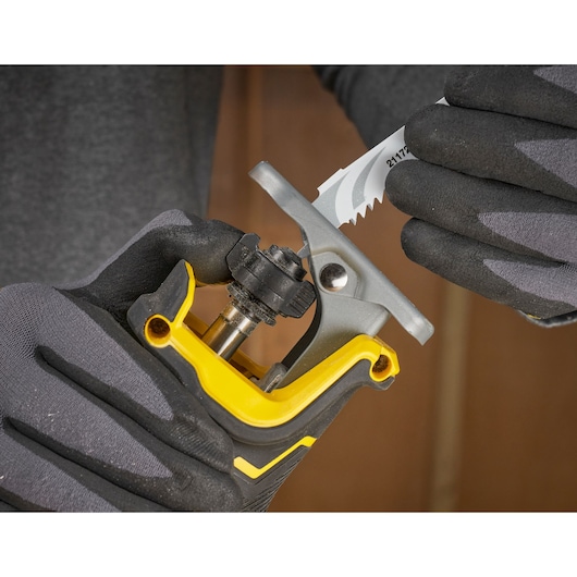 STANLEY SFMCS311M1T figuurzaagblad wordt geplaatst, close-up met handschoenen en zichtbare gereedschapsdetails.