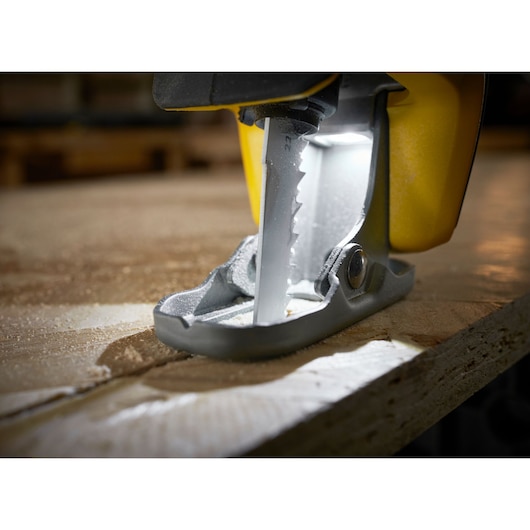 STANLEY SFMCS311M1T decoupeerzaag zaagt hout, close-up van blad en voet, verlicht door LED-licht.