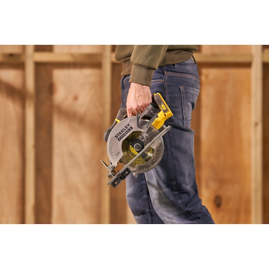 Stanley SFMCS500B scie circulaire sans fil tenue par une personne, présentée en atelier.