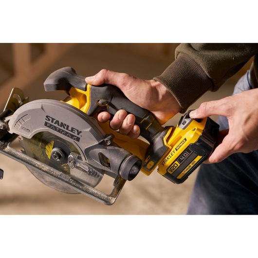 Stanley SFMCS500M1S scie circulaire tenue à la main, angle rapproché, photographie jaune et noire.