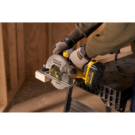 Stanley SFMCS500M1S scie circulaire coupant du bois, gros plan, utilisateur avec des gants.