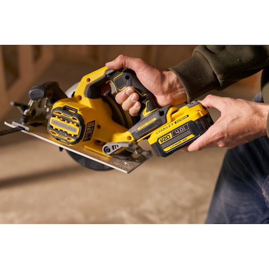 Photographie de la scie circulaire sans fil STANLEY SFMCS550M2K, moteur brushless, batterie V20 lithium-ion, en utilisation.