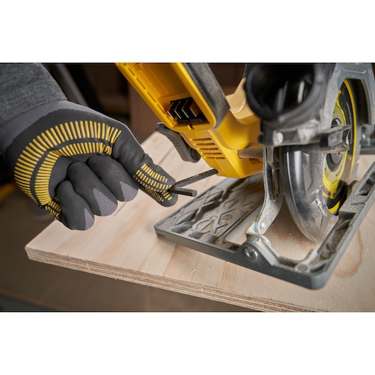 STANLEY SFMCS551M1T cirkelzaag close-up, handschoen hand past de basis aan op multiplex.