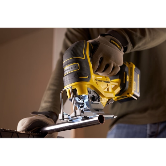 Photo de la scie sauteuse STANLEY SFMCS650M2K 18V STANLEY FATMAX V20 Brushless coupant un tuyau métallique, en utilisation.