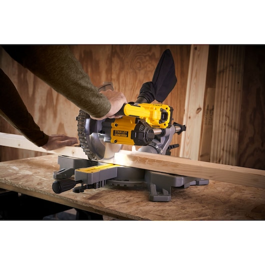 STANLEY SFMCS701M1 scie à onglet en action coupant du bois, atelier, vue latérale.