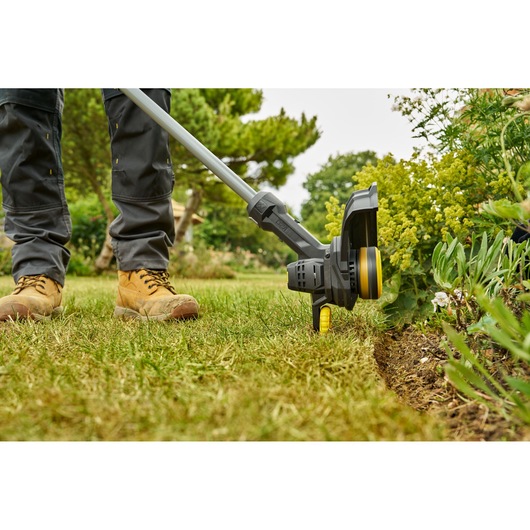 STANLEY SFMCST925M1 coupe-bordures utilisé pour tailler le bord de la pelouse, vue rapprochée en extérieur.