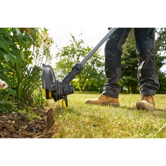 STANLEY SFMCST925M1 coupe-bordure utilisé pour délimiter une pelouse, photo extérieure en gros plan.