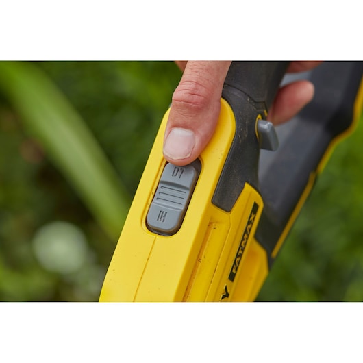 STANLEY SFMCST933M1 close-up van de schakelaar op gele gereedschapshandgreep buiten.