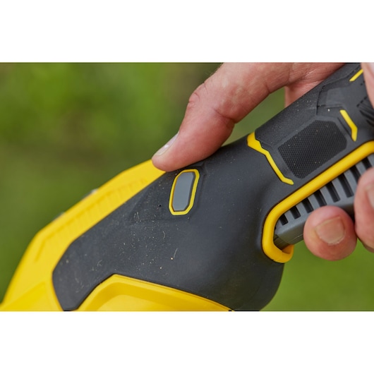 STANLEY SFMCSTB933B handgreep van elektrisch gereedschap in zwart en geel met vinger op de knop, close-upfoto.