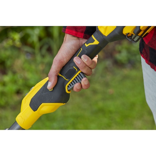 STANLEY SFMCSTB933M graskantenmaaier handvat close-up, vastgehouden, zwarte en gele afwerking.