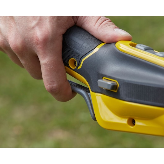 Foto van de handgreep en trekker van de STANLEY SFMCSTB963B trimmer in close-up.