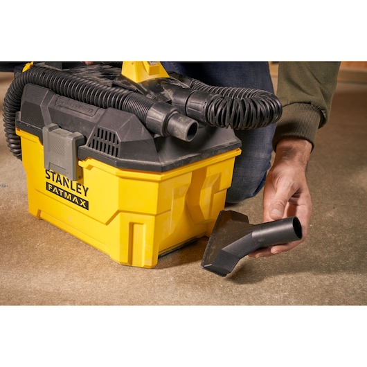 Photographie de l’aspirateur STANLEY SFMCV002B avec corps jaune, tuyau noir et accessoire buse au sol.