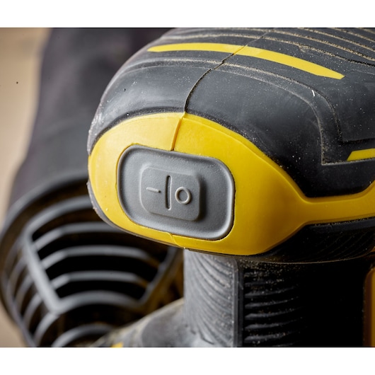 STANLEY SFMCW220B détail de l’interrupteur de ponceuse jaune et noire, photographie en gros plan.