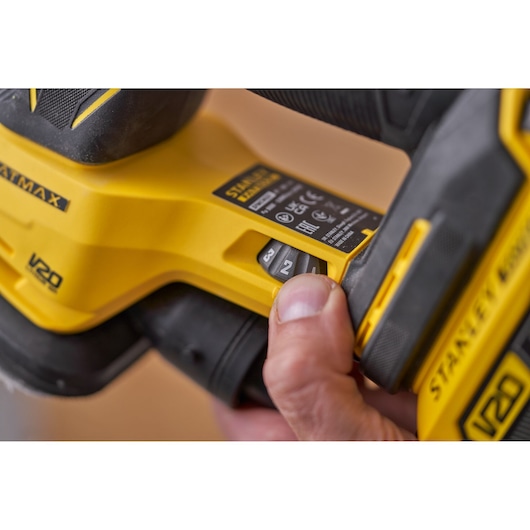 Foto van STANLEY SFMCW221D1S schuurmachine, close-up van snelheidsregelaar en geel-zwarte behuizing.