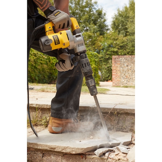 STANLEY SFMEH220K-QS boorhamer breekt beton buiten, close-up van gereedschap in gebruik.