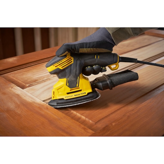 Stanley SFMEW210S ponceuse sur surface en bois, gros plan, design jaune et noir, photographie d’outil électrique.