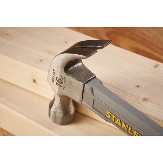 STANLEY STHT0-51309 klauwhamer met stalen kop en grijze handgreep op houten planken, close-up.