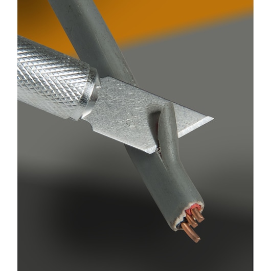 Couteau STANLEY STHT0-73872 coupant un câble électrique gris, angle rapproché, photographie produit.