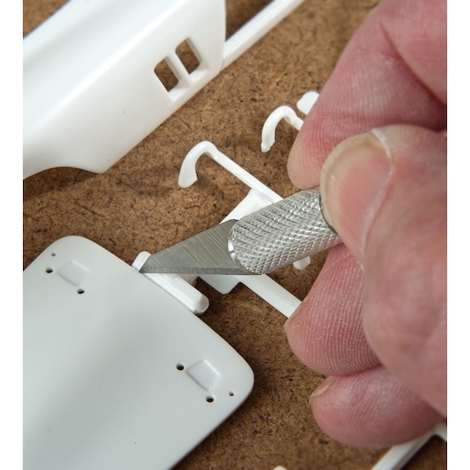 STANLEY STHT0-73872 couteau de précision pour loisirs découpant des pièces de modèle en plastique blanc, photo en gros plan.