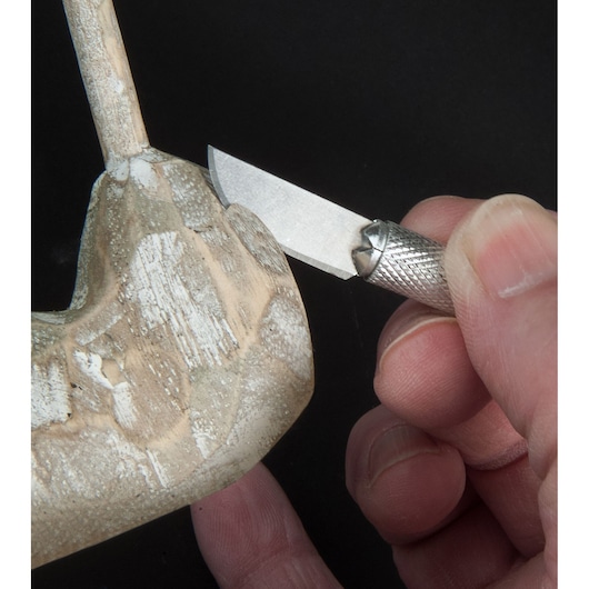 STANLEY STHT0-73872 couteau de précision utilisé pour sculpter le bois, photo rapprochée de la lame et du bois.