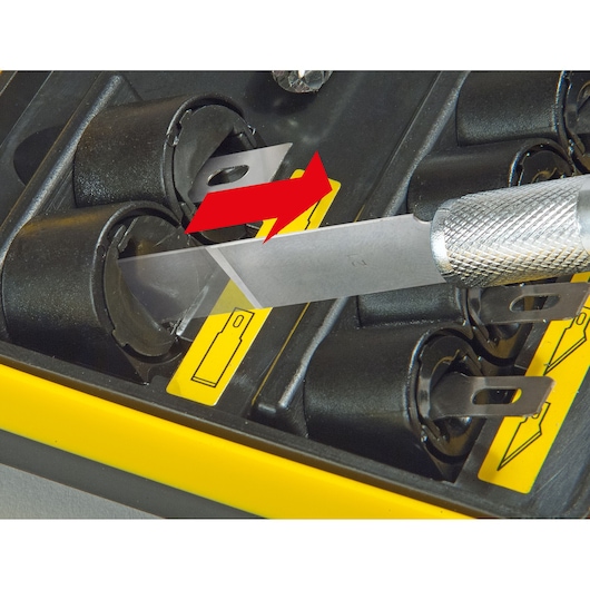 STANLEY STHT0-73872 lame de couteau insérée dans un étui de rangement noir avec étiquette jaune, photo en gros plan.