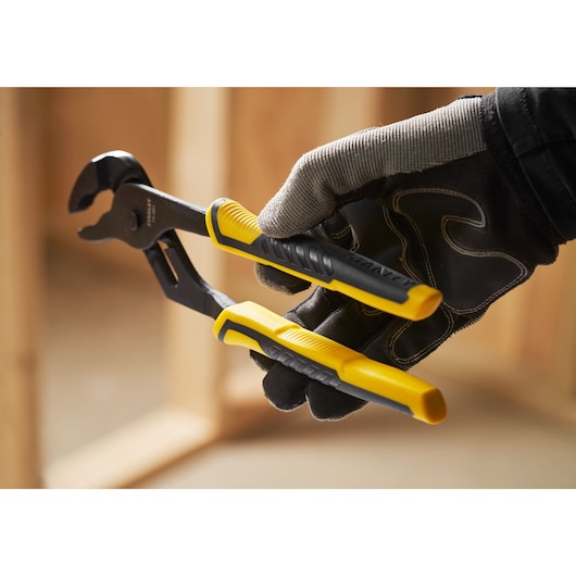 STANLEY STHT0-74361 pince multiprise avec poignées jaune et noire tenue par une main gantée, gros plan.