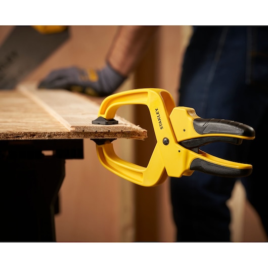 STANLEY STHT0-83200 veerklem op werkbank houdt hout vast, close-up tijdens houtbewerking.