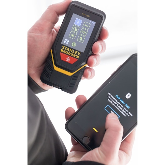 STANLEY STHT1-77139 laserafstandsmeter in hand, koppeling met smartphone via Bluetooth.