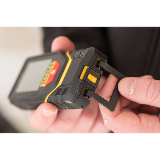 STANLEY STHT1-77139 laserafstandmeter met uitschuifbare clip, close-up in de hand.