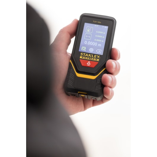 Foto van STANLEY STHT1-77139 FATMAX laserafstandsmeter in de hand, frontdisplay zichtbaar.