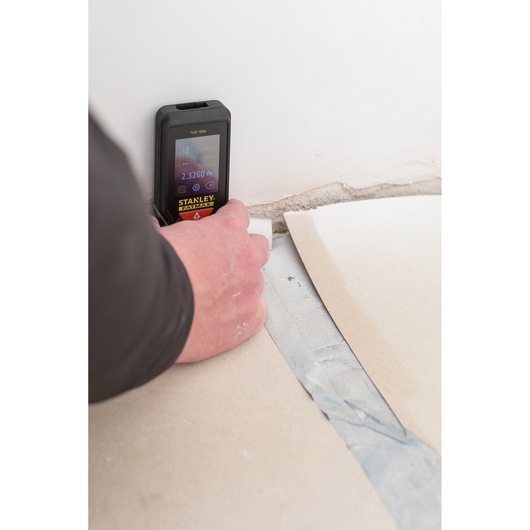 STANLEY STHT1-77142 télémètre laser utilisé dans un angle de mur et sol.
