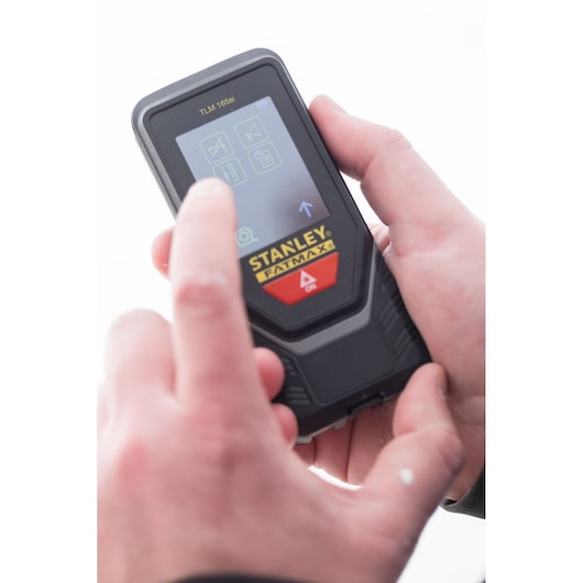 Photo du télémètre laser STANLEY STHT1-77142 utilisé, utilisateur interagissant avec l'écran tactile.