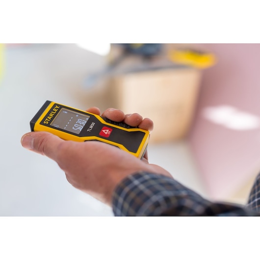 STANLEY STHT1-77409 télémètre laser tenu en main, photographie rapprochée en intérieur.