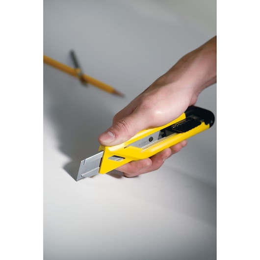 STANLEY STHT10265-0 stanleymes met gele en zwarte handgreep in hand snijdt witte ondergrond.