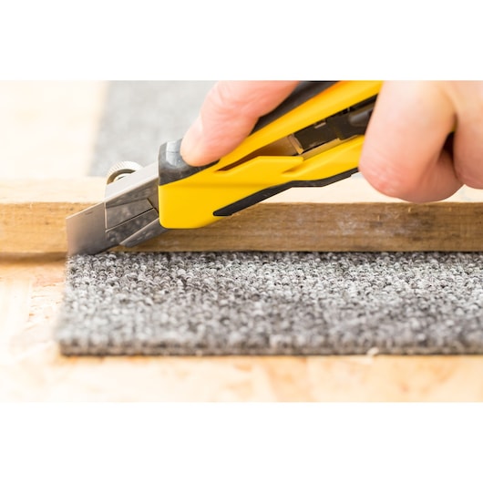 STANLEY STHT10270-0 stanleymes snijdt grijs tapijt naast hout, close-up fotografie.