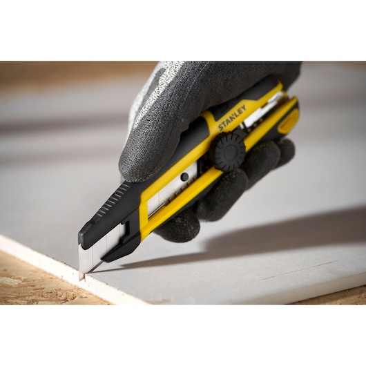 Foto van STANLEY STHT10500-0 hobbymes met geel-zwart handvat dat gipsplaat snijdt.