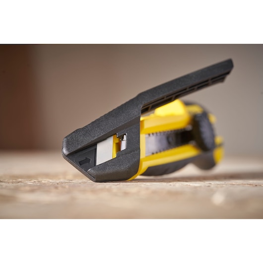 STANLEY STHT10500-0 steekmes close-up, geel en zwart, schuine hoek op houten oppervlak.