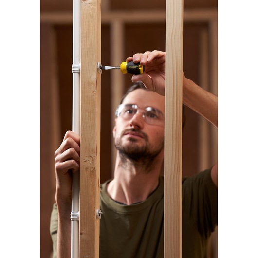 STANLEY STHT16147-0 tournevis utilisé pour serrer une vis sur une charpente en bois, photographie produit.