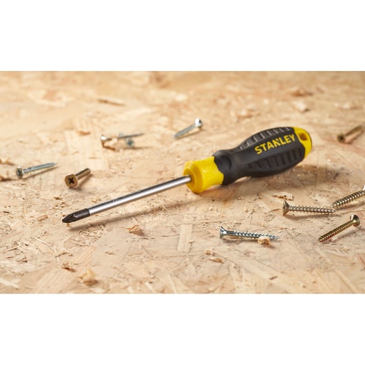 Stanley STHT16163-0 zwart-gele Phillips schroevendraaier op hout met verspreide schroeven.
