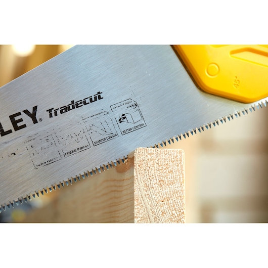 STANLEY STHT20348-1 handzaag met scherpe tanden zaagt hout, close-up van het blad en handvat.