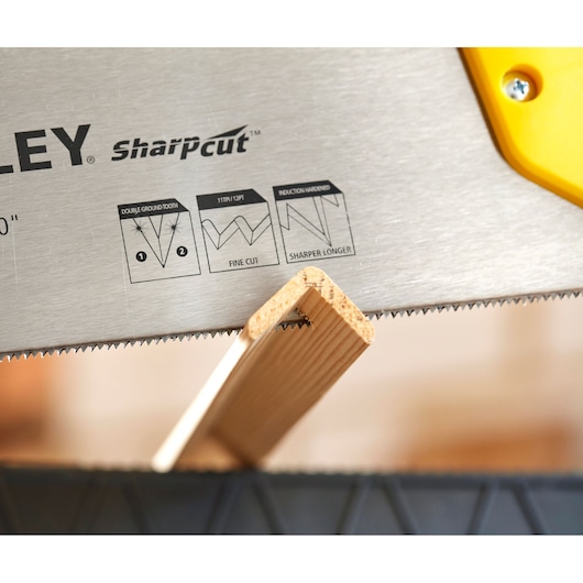 STANLEY STHT20371-1 lame de scie à main avec dents SharpCut coupant une planche de bois, photo en gros plan.