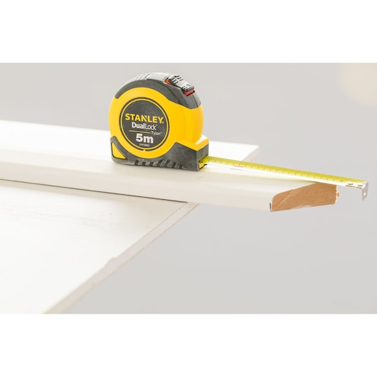 STANLEY STHT36803-0 rolmaat op witte plank, geel-zwarte behuizing, 5m lengte zichtbaar.