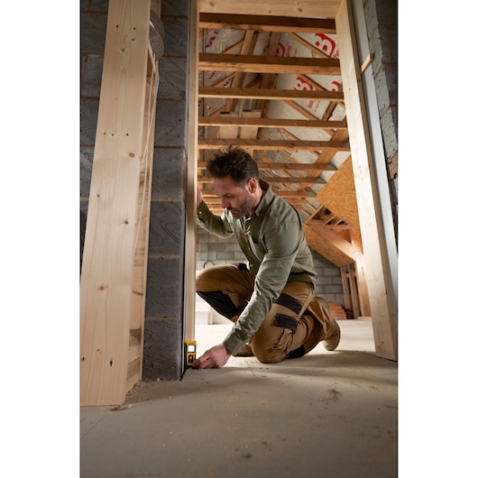 STANLEY STHT77065-0 télémètre laser utilisé sur un chantier, mesure du sol au mur.