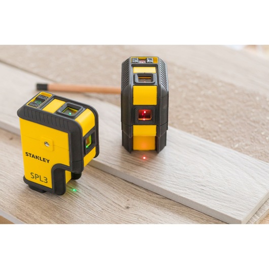 STANLEY STHT77503-1 laserwaterpas geel en zwart, op houten plank, zij- en voorkant zichtbaar.