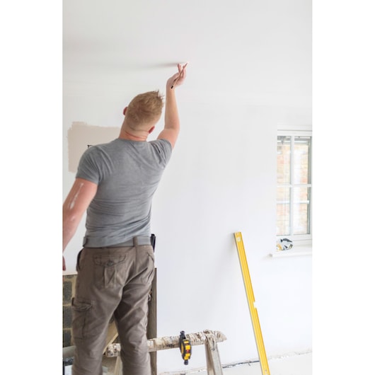 STANLEY STHT77503-1 gele waterpas tegen muur bij interieur renovatie, fotografie zijaanzicht.