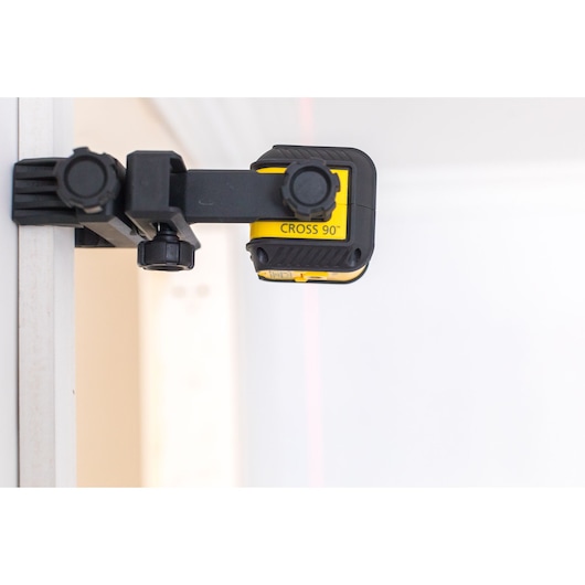 STANLEY STHT77592-1 kruislijnlaser gemonteerd op muur, zijaanzicht, geel en zwart ontwerp.