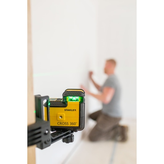 Foto van STANLEY STHT77594-1 Cross 360° laserwaterpas op klem, projecteert groene lijn in kamer.