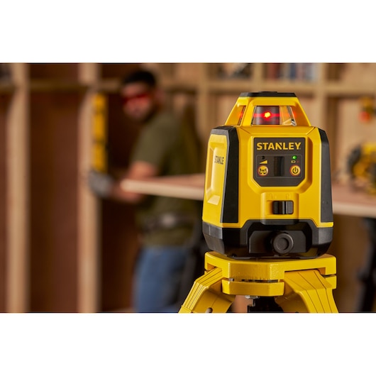 Photo du niveau laser jaune STANLEY STHT77616-0 sur trépied, utilisé pour l’alignement en construction.