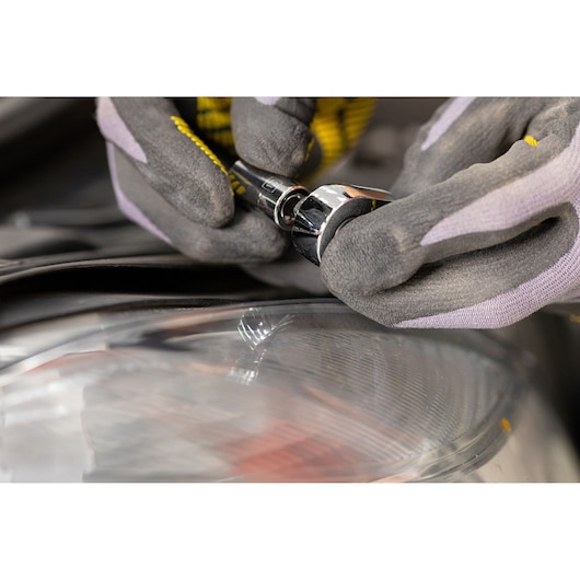 STANLEY STMT82663-0 ratel wordt met handschoenen gebruikt naast een koplamp van een auto, close-up fotografie.