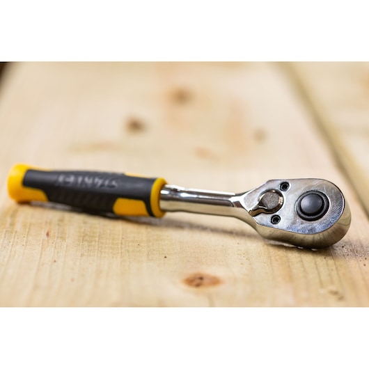 STANLEY STMT82663-0 ratelsleutel met geel-zwart handvat op houten ondergrond, productfotografie.